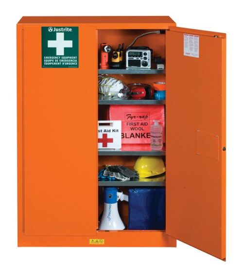 The Justrite Cabinet Emerg W/Port 65X43 Org is open, displaying safety gear like a flashlight, radio, gloves, first aid kits, wool blanket, hard hat, goggles, and a megaphone. It features a prominent Emergency Equipment sign on top.
