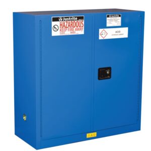 The blue Justrite Cabinet, Haz Mat 30G Sc, features Hazardous Keep Fire Away and Acid Storage Cabinet labels. It includes two doors, a lock, and a side vent for safe acid storage.