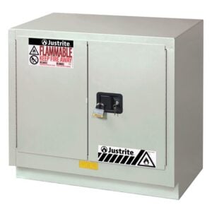 The Justrite Cabinet FMHD 23G/36 Man Ltnul is a gray cabinet with two padlock-secured doors, showcasing warning labels and safety symbols that prominently display Flammable and Keep Fire Away for enhanced safety.