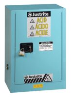 The Justrite Cabinet, Acid Cmp 12G, Man Blu for corrosive materials has a secure lock on the handle and displays safety symbols with labels in English, Spanish, and French.