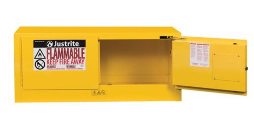 The yellow Justrite Flam Pigy 12G cabinet stands open, showcasing a FLAMMABLE KEEP FIRE AWAY warning label. The interior is empty with additional safety labels visible on the door.