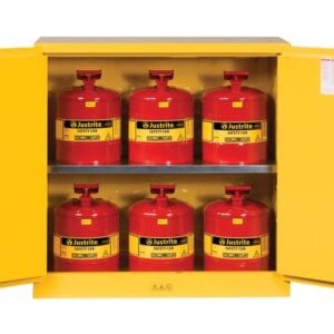 A yellow Justrite Cabinet is open, displaying six red Justrite safety cans with handles and spouts. The interior label on the left door shows safety instructions, ideal for securely storing Flam W/Cans 30G Mn Yl items.
