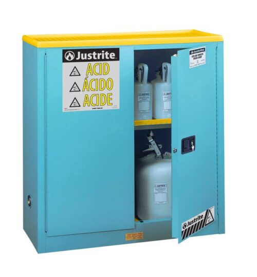 A blue Justrite Cabinet, model Acid Sfty 30G Man Blu, with a yellow top is partially open, revealing plastic containers inside. The door is labeled with caution signs and ACID in various languages for universal safety and clarity.
