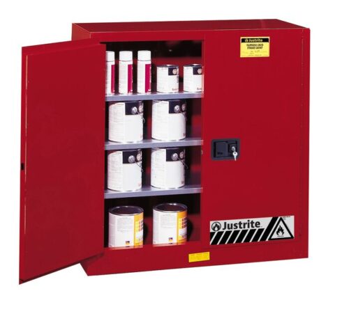 A Justrite Cabinet, Cmbs P&I 40G, Man Red stands open with its shelves filled with cans and containers. A warning label emphasizes its safety features. Ideal for securely storing flammable materials, this cabinet is essential for any safe workspace.