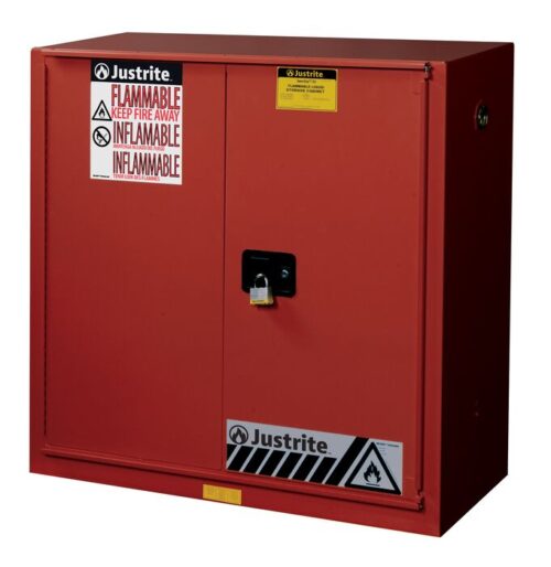 The Justrite Cabinet P&I 40G in red features bifold doors, a sturdy black handle, and clear warning labels, ensuring that hazardous materials are stored safely away from fire risks.