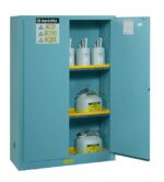 The Justrite Cabinet, Acid Sfty 45G Man Blu, in vibrant blue, stands open to reveal three shelves with six containers labeled for safety or acid. Prominent safety warning labels on its door ensure secure storage.