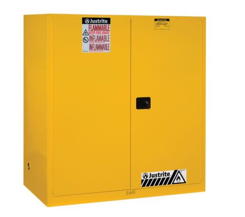 The Justrite Cabinet is a yellow flammable liquid storage unit with dual doors. It features multilingual Flammable labels and warning symbols on the front. It is compatible with Vdrum (2)55G Sc Yel containers for enhanced safety.