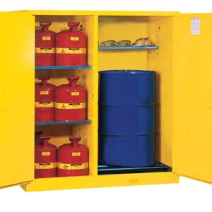 A Justrite Cabinet is open, showcasing red safety containers with yellow labels on the left and a Cmbo Vdrum/Rlr Mn Yel at the bottom right, with safety goggles and gloves on the shelf above.