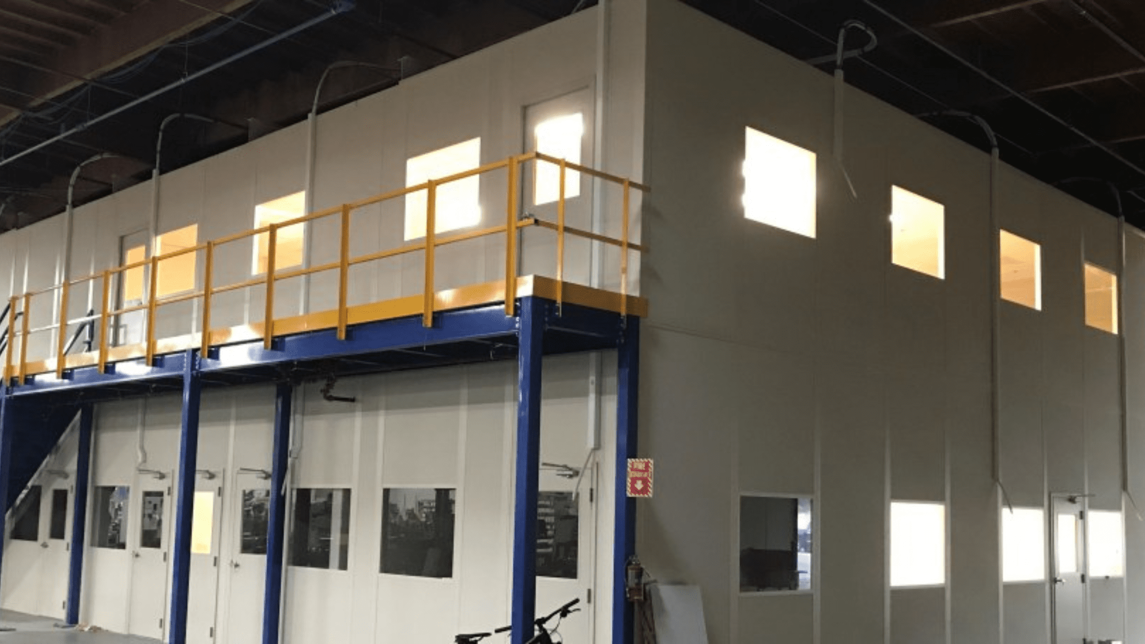 Prefabricated modular office building with windows installed inside an industrial shell