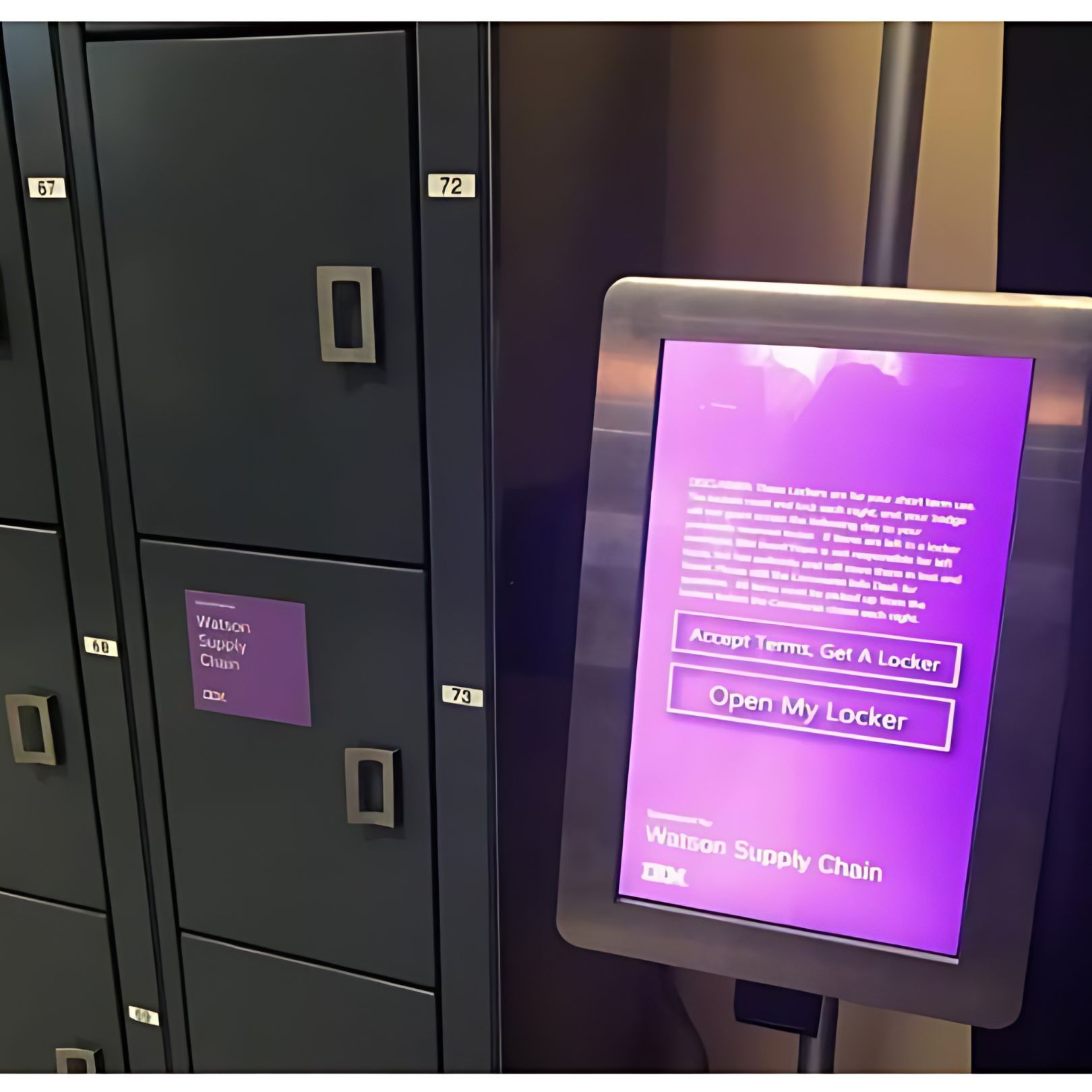 A digital screen and a row of lockers meet the eye. The screen flaunts a purple interface offering options to accept terms and open lockers. Each is tagged Watson Supply Chain, with some numbers visible: 67, 71, 72, and 73.