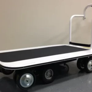 A Pony Express Motorized Platform Truck by Electro Kinetic Technologies features a black surface, six wheels, and a white handlebar on a gray floor against a beige wall. With its 52 L x 34 1/2 W deck and robust 4000 lb. capacity, its ideal for heavy-duty tasks.