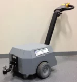 The gray Electro Kinetic Technologies Pony Express Electric Tugger, with large wheels and a 2 ball hitch, features a long handle and effortlessly handles up to 5000 pounds.