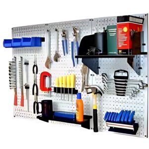 A wall-mounted pegboard neatly displays home products and supplies: wrenches, pliers, hammers, screwdrivers, and clamps. Blue bins hold smaller items. A shelf holds spray bottles and container boxes, ensuring an organized workspace.