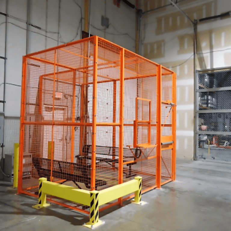 A large, industrial metal cage with orange mesh stands in a spacious warehouse with unfinished walls. Within the secured area, mobile shelving units are neatly organized, safeguarded by yellow barriers featuring black diagonal stripes.