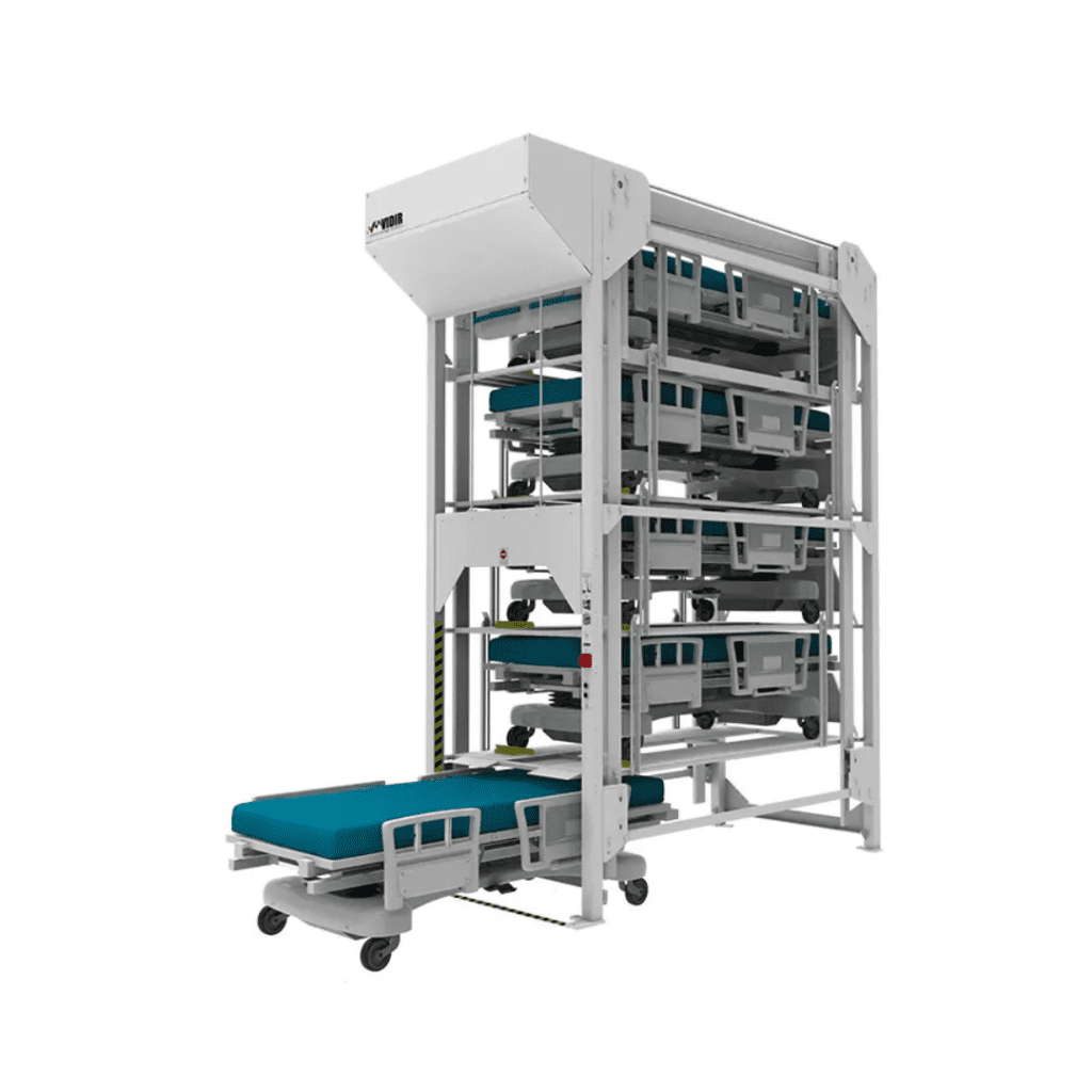 A tall, multi-tiered hospital bed storage system is displayed, featuring Pegasuss RFID Failsafe Medical Inventory System. The structure is white with teal mattresses stacked vertically, and a bed on wheels is partially extended at the bottom level.