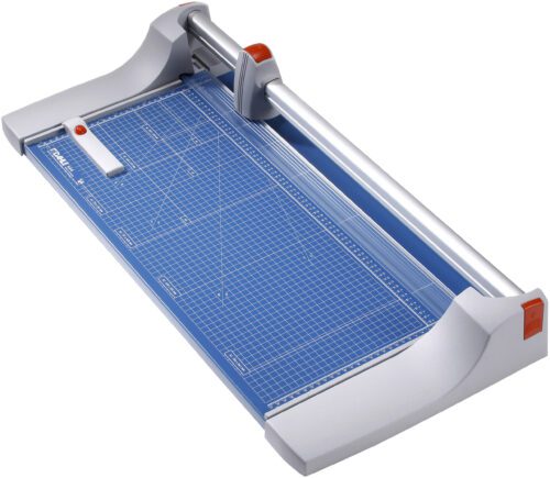 The Dahle 444 Premium Rotary Trimmer features a 26 cut length and a sleek gray and blue design. It includes a grid-lined cutting surface, sliding blade handle for precise trimming, and measurement markings for accuracy.