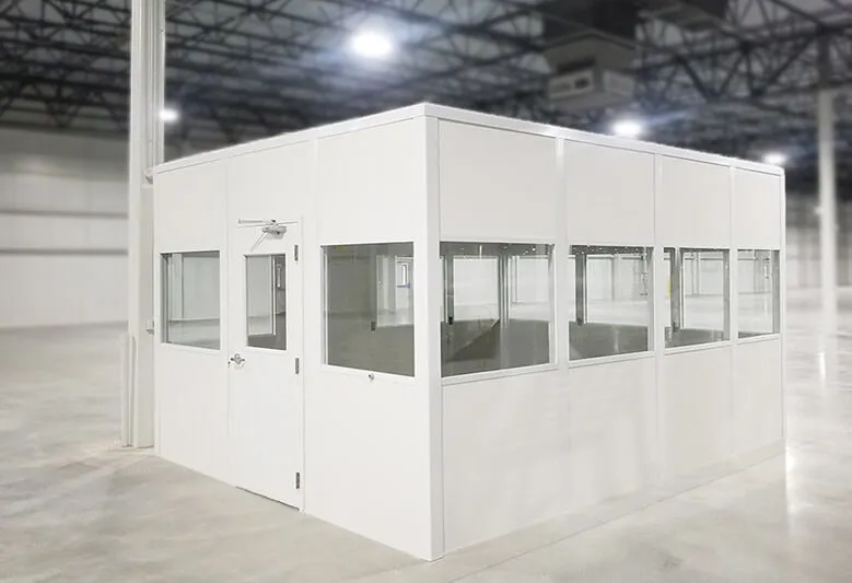 A white, modular shipping office with glass windows and a door sits in a spacious warehouse with a high ceiling, expertly designed for efficient receiving operations.