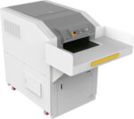 The Dahle PowerTEC® 929 IS Conveyor Shredder is a robust gray industrial machine for paper processing, featuring a button-equipped control panel, display, wide input tray, and wheels for mobility. It maintains its rectangular shape and sturdy construction.