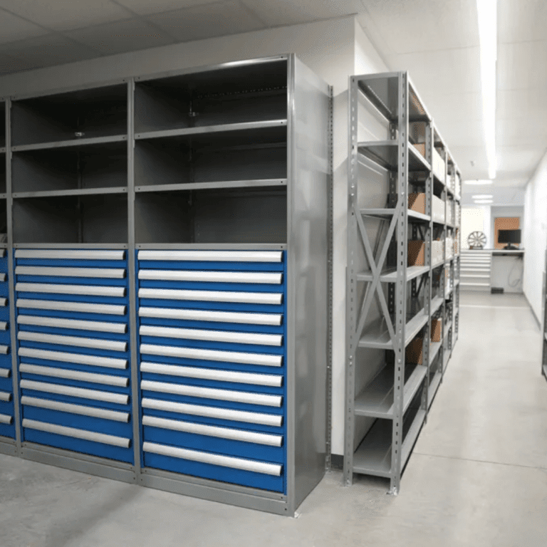 Metal shelving units with attached blue cabinets and gray handles rest on a concrete floor. The left unit boasts labeled automotive modular drawers, while the right stores various items. In the background, more shelves sit beside a dartboard on the wall.
