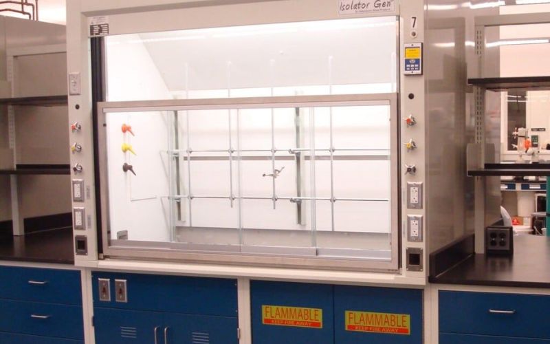 Bench-top laboratory fume hood with a glass sash on base cabinets