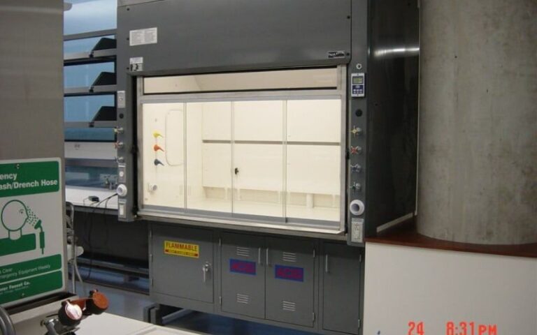 Benchtop fume hood installed above laboratory casework with flammable storage cabinets below
