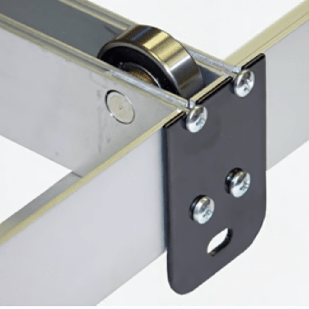 Close-up of a metal sliding mechanism featuring a black bracket and roller wheel, typical of Pipp Mobile Storage Systems. The structure includes a metal frame with screws securing the components. The background remains plain and out of focus.