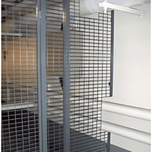 A modern interior featuring sleek metal grid structures resembles a sophisticated chain link storage cage. Rectangular panels form a geometric pattern, with horizontal and vertical lines creating depth against bright, minimalistic wall elements.