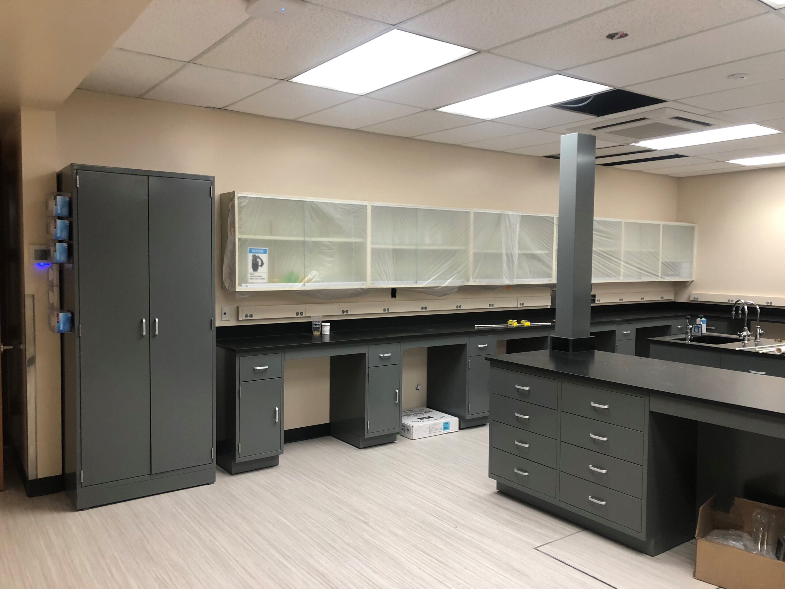 Bright university teaching laboratory with glassware shelving, casework and student benches