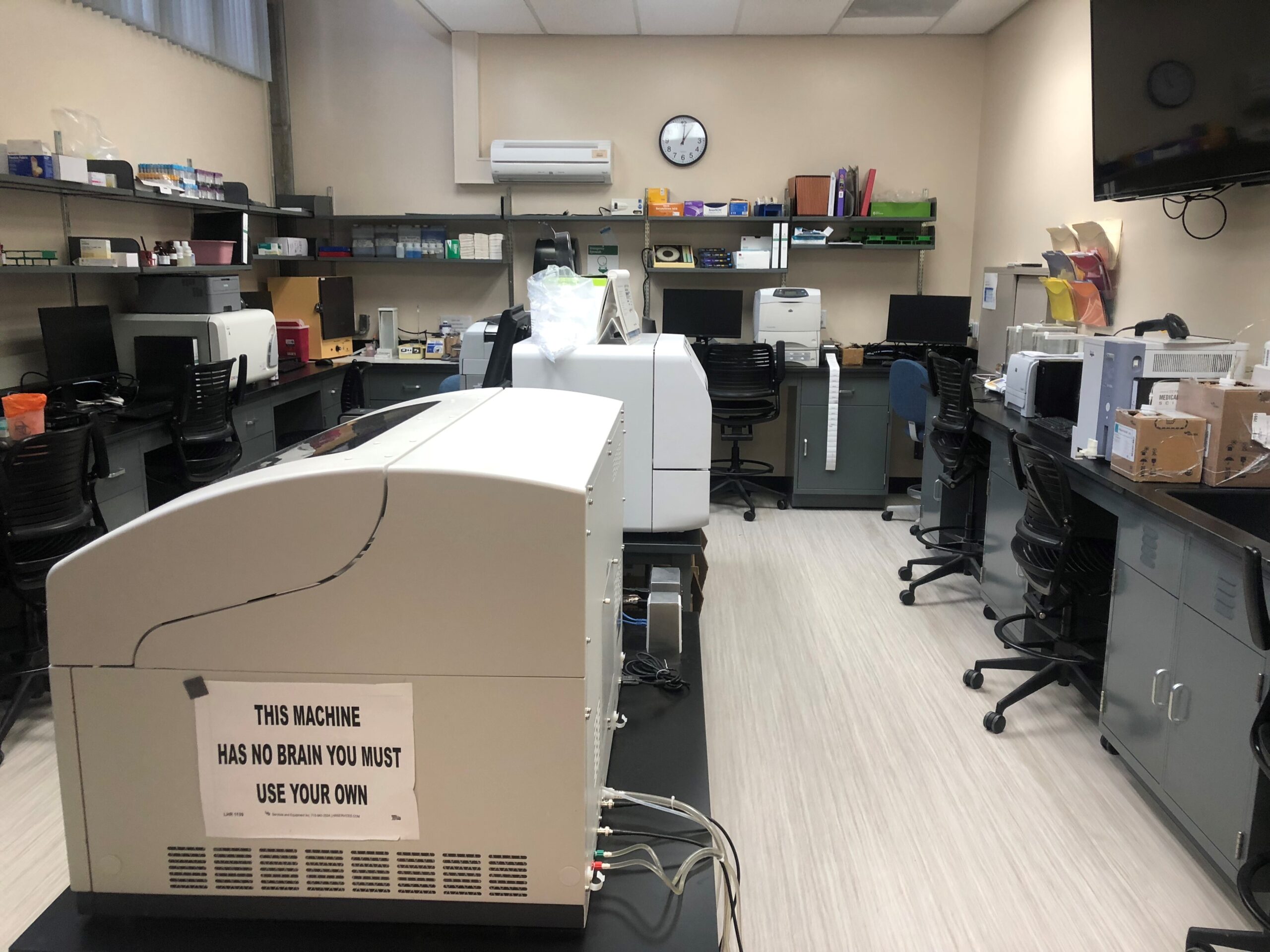Research laboratory bench run with black work surfaces, wall casework and a workstation