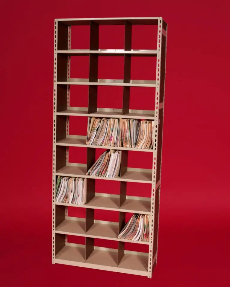 A tall, beige shelving unit, embodying Storage Solutions with BASC, features multiple compartments filled with diverse folders and documents, standing proudly against a solid red backdrop.