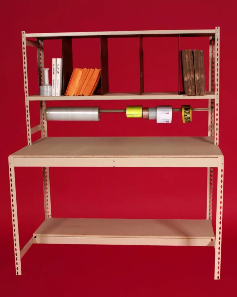 Beige metal shelving unit against a red backdrop, featuring organized compartments of white and orange papers, books, and a central rod for clear wrap, tape, and caution tape. This sleek design epitomizes Storage Solutions with BASC, complemented by a wooden tabletop and lower shelf.