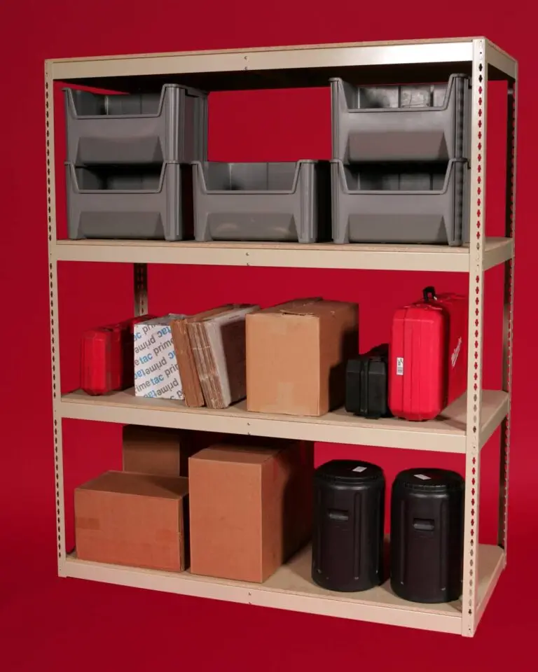 A beige metal shelving unit against a red background showcases BASCs innovative storage solutions, holding gray plastic bins, cardboard boxes, and red hard cases. Each shelf is meticulously organized for optimal storage efficiency.