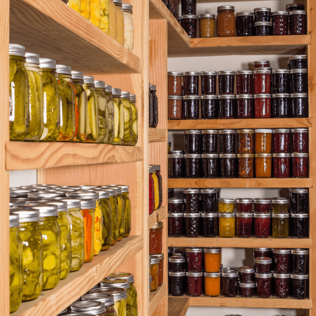 Shelves filled with various glass jars containing pickled vegetables and preserves line the walls, offering a glimpse into the art of food service. The jars are neatly arranged on wooden shelves, showcasing a colorful assortment of homemade canned goods.