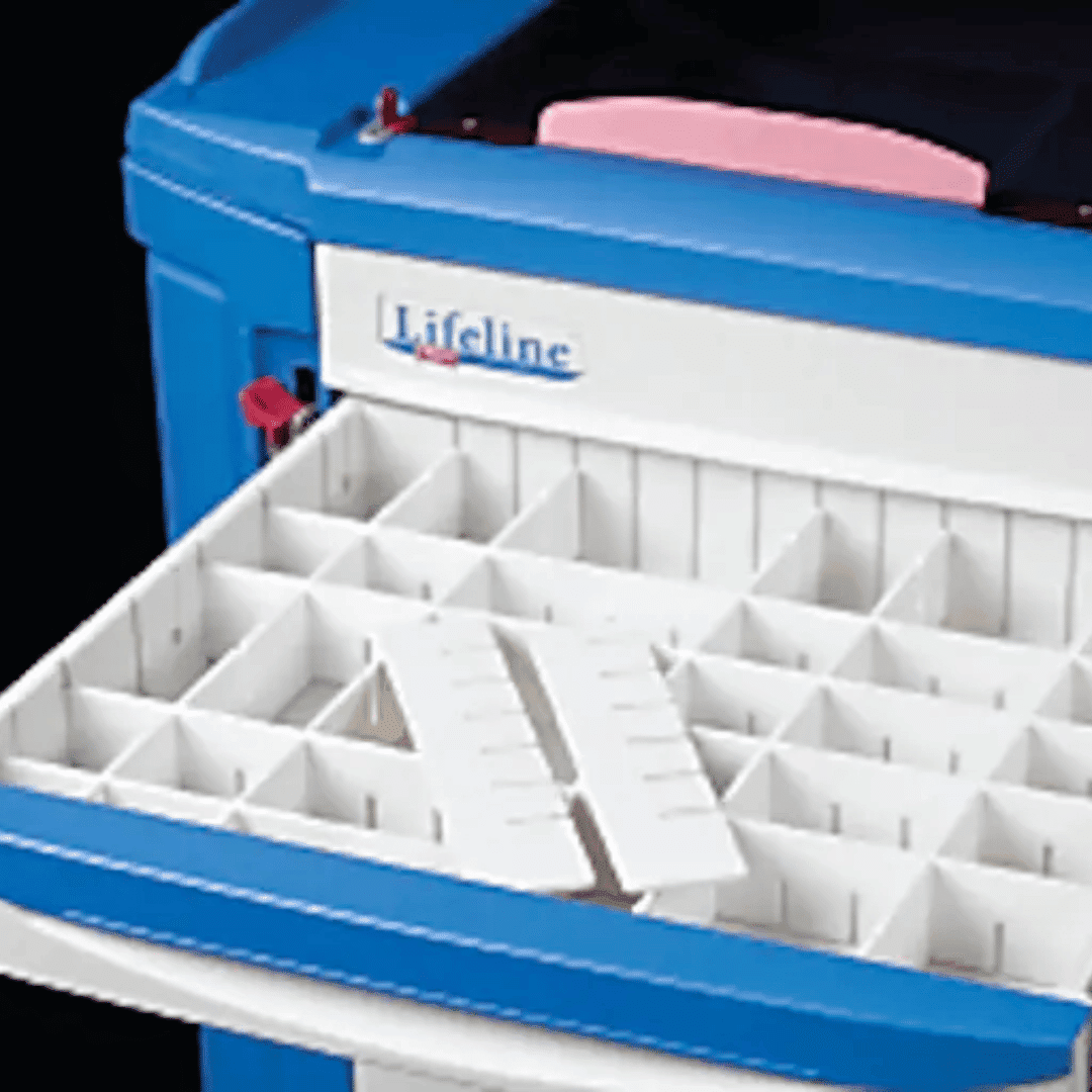 A blue Lifeline Crash Cart features a white drawer partially open, revealing small compartments and an adjustable divider. A pink object rests at the back of the top compartment. The cart proudly bears the label Lifeline.