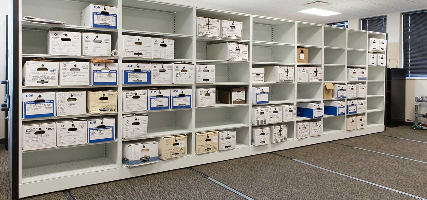 High-density mobile shelving ranges mounted on floor track in a records and evidence storage room
