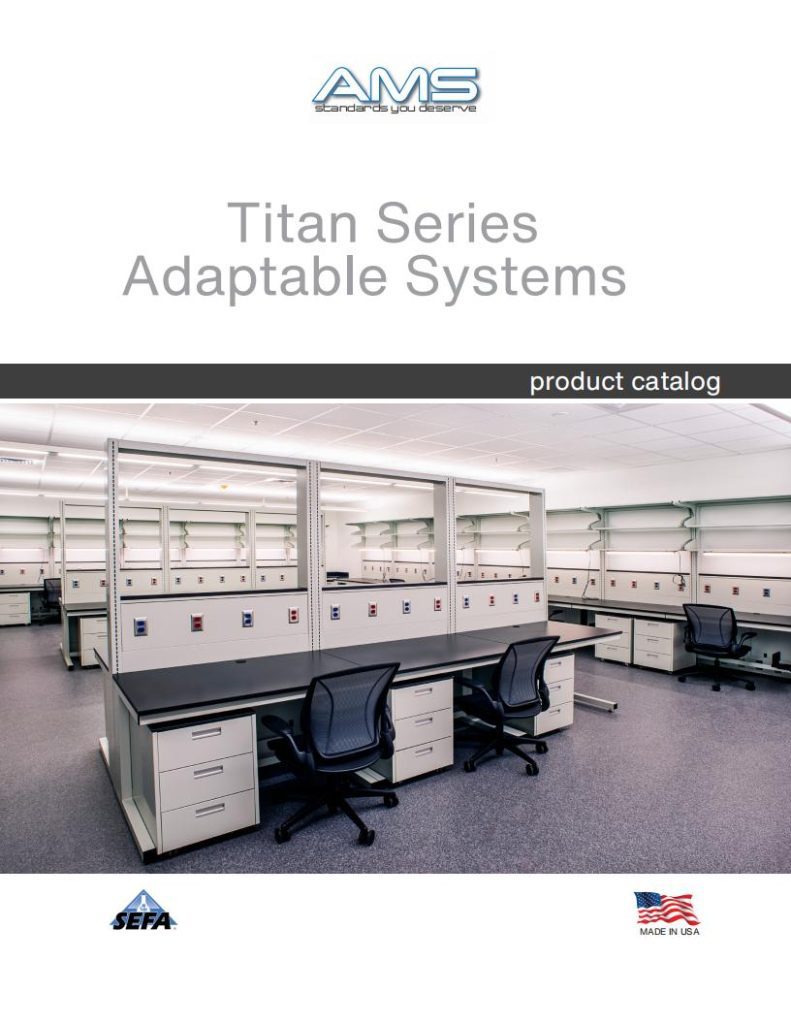 A catalog cover depicting a modern laboratory with workstations, desks, chairs, and overhead shelves. The text reads, AMS Titan Series Adaptable Systems product catalog, featuring custom laboratory equipment like laboratory fume hoods. Flags and logos appear at the bottom.