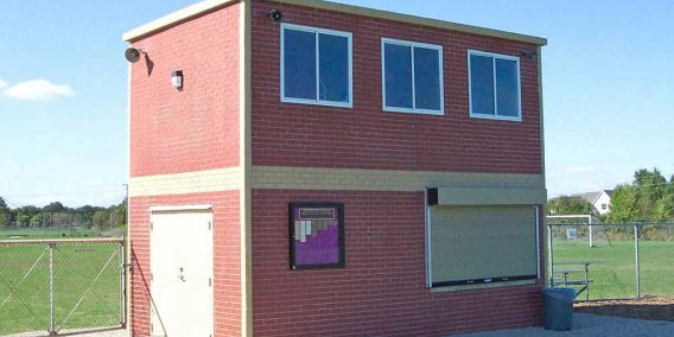 Two-level sports-facility building with upper press-box windows