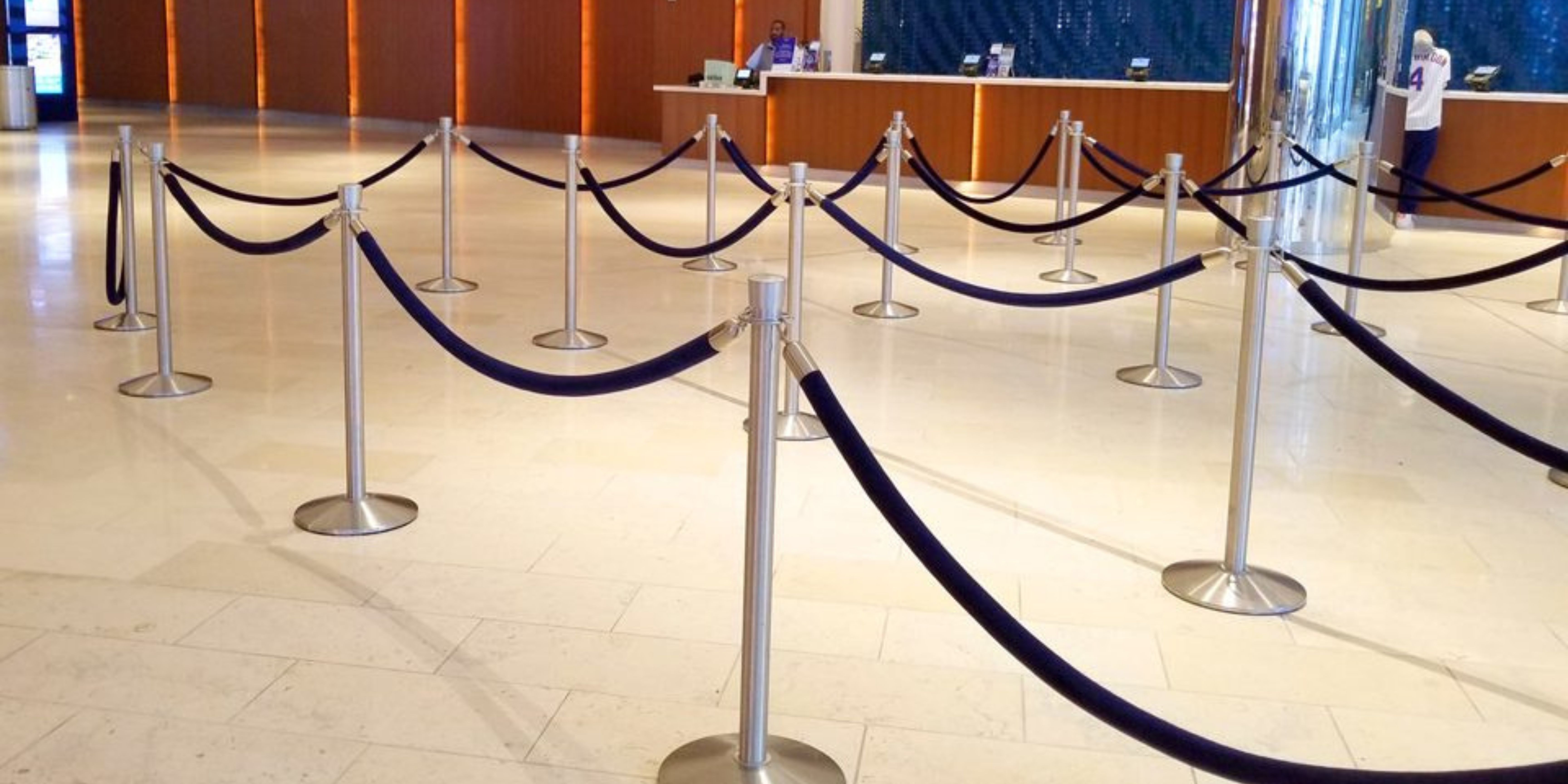 Hotel lobby with stainless classic post and rope stanchions forming a switchback queue in front of a reception desk