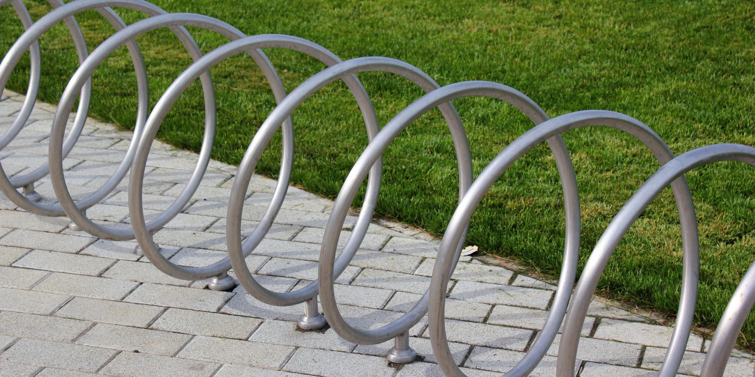 Outdoor spiral bicycle rack beside a paved path