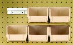 Six ivory Quantum Hang-N-Stack Bins (Qus220) with dimensions 7-3/8L x 4-1/8W x 3H, along with two bin rails, are mounted on a pegboard wall in two rows—three on top and three below—efficiently utilizing the pegged wall space for an organized look.