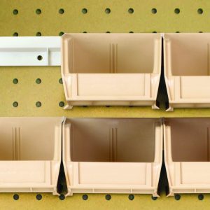 Six ivory Quantum Hang-N-Stack Bins (Qus220) with dimensions 7-3/8L x 4-1/8W x 3H, along with two bin rails, are mounted on a pegboard wall in two rows—three on top and three below—efficiently utilizing the pegged wall space for an organized look.