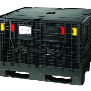 The black Quantum Collapsible Bulk Box Lid, proudly made in the USA, features a gridded texture with two front handles, red and yellow locking clips, a Place Label Here slot, and sits on a pallet base—ideal for durable shipping needs.