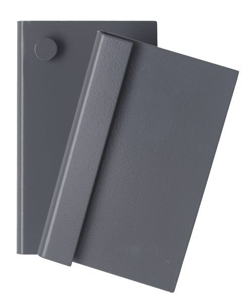 Two overlapping dark gray books rest on a white surface, subtly resembling the sleek design of the Quantum Louvered Panel Bracket for QTB Tip-Out Bins. The top book is slightly tilted over the other, with a small circular object at its upper left corner.