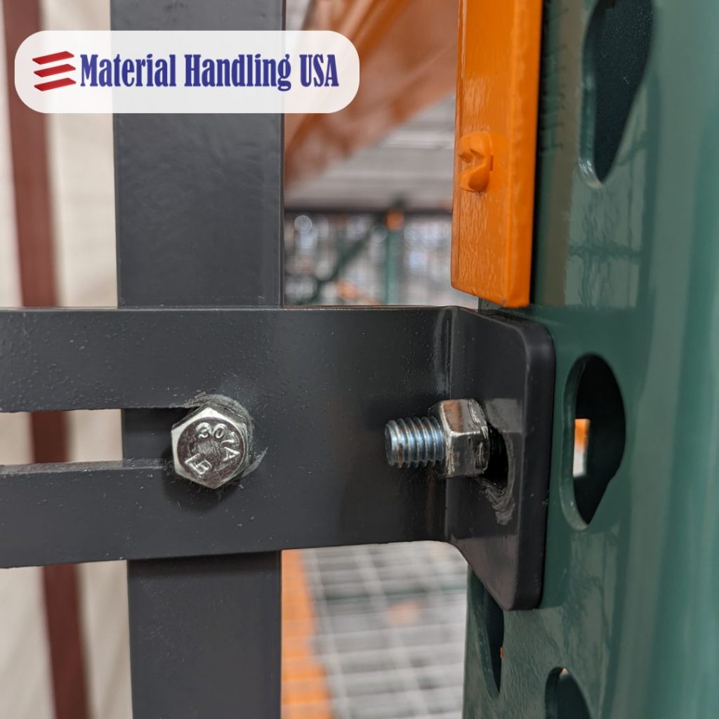 Close-up of a metal bolt securing a beam to a green and orange industrial shelf, reinforced with pallet rack backing for added stability. The logo in the top left corner reads Material Handling USA in blue text.