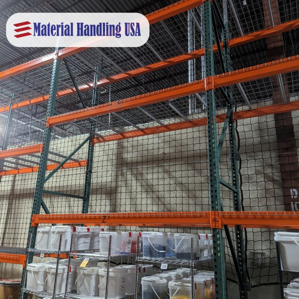 Industrial storage shelving with orange beams and a black netting backdrop is seen in the pallet rack backing image. Several plastic bins are arranged on the lower metal rack. The Material Handling USA logo is displayed in the top left corner.