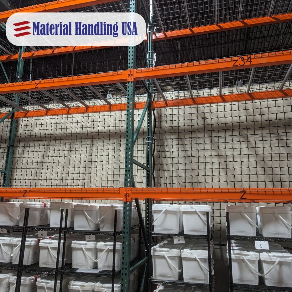 Warehouse shelving featuring orange metal beams and protective pallet rack backing. White plastic bins are neatly stocked on the lower shelves. The Material Handling USA logo is displayed in the top left corner, emphasizing safety and organization.