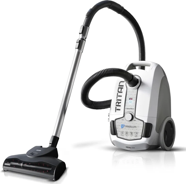 A white canister vacuum cleaner, a staple in janitorial equipment and supplies, features a long hose and power nozzle attachment. It has wheels for mobility and Tritan on its body, while the front panel details its advanced filtration system.