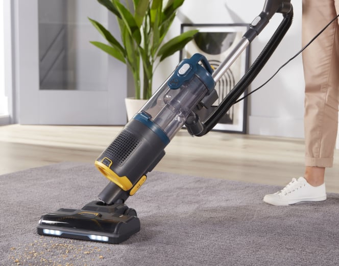 Vacuum and half of the feet and leg of a woman who seems to use the floor vacuum