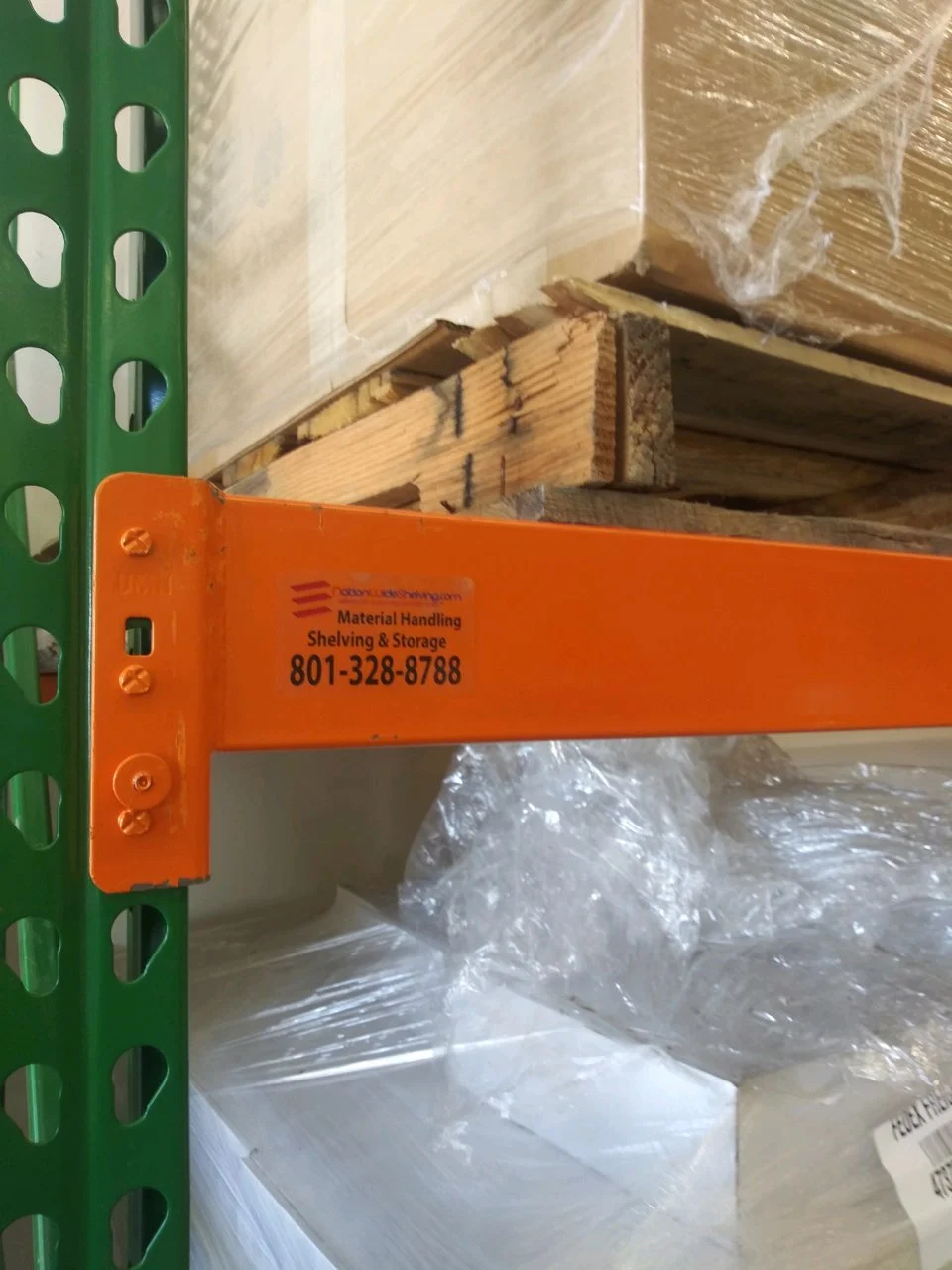 Seismic-compliant pallet racks with reinforced beams and safety labels, ensuring stability and compliance in warehouse environments.