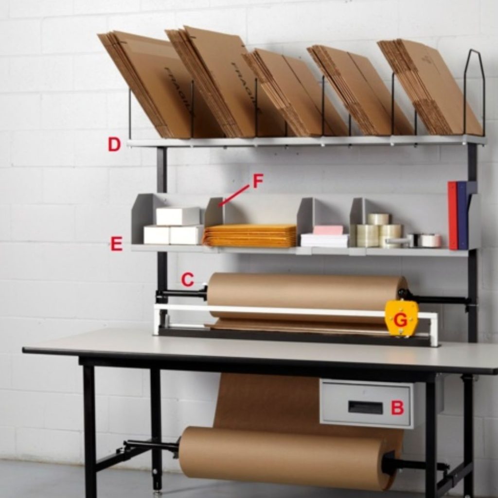 A packaging station featuring shelves filled with brown envelopes, small boxes, and packing tape. A large brown paper roll is mounted below, and a cutter with a measuring tape is attached in front.
